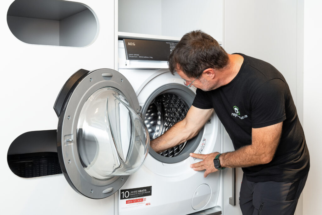 Reparatur.at Techniker schaut in Waschmaschine © Michael Schnabl