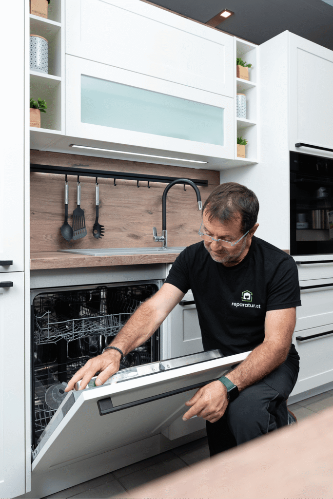 Techniker &ouml;ffnet Geschirrsp&uuml;ler zur Reparatur